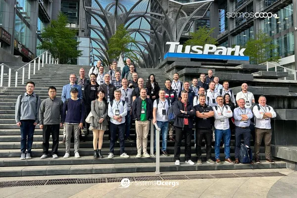 Grupo de gestores do Sicredi posa em frente ao prédio da TusPark, na China, durante missão internacional focada em inovação e tecnologia, com destaque para a arquitetura moderna ao fundo. 