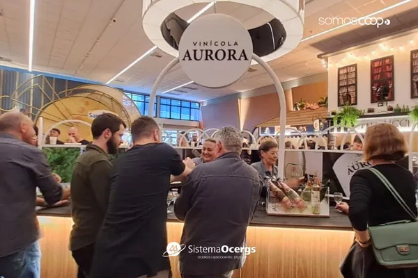 Visitantes degustam vinhos e espumantes no estande da Vinícola Aurora. O espaço destaca rótulos e a tradição cooperativista, com ambiente acolhedor e interativo.