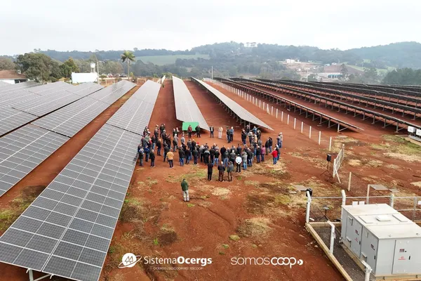Cerimônia de inauguração da usina UFV Creral FX4 em Erechim, com associados reunidos entre fileiras de painéis solares.