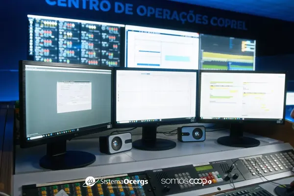 Centro de Operações da Coprel Soluções com telas de monitoramento e técnico em atividade, evidenciando a estrutura tecnológica para gestão de usinas.