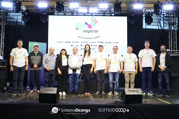 Representantes das cooperativas de Marau no palco do Dia C, com camisetas do evento, diante de telão com logotipos do Sistema Ocergs, SomosCoop e cooperativas participantes.