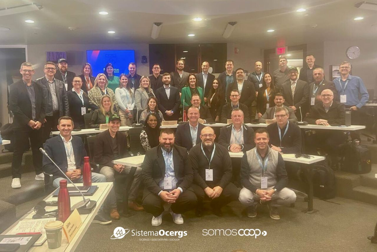 Grupo de cooperativistas do Sistema Ocergs em missão internacional, reunidos em sala de aula para capacitação, com clima de integração e aprendizado.