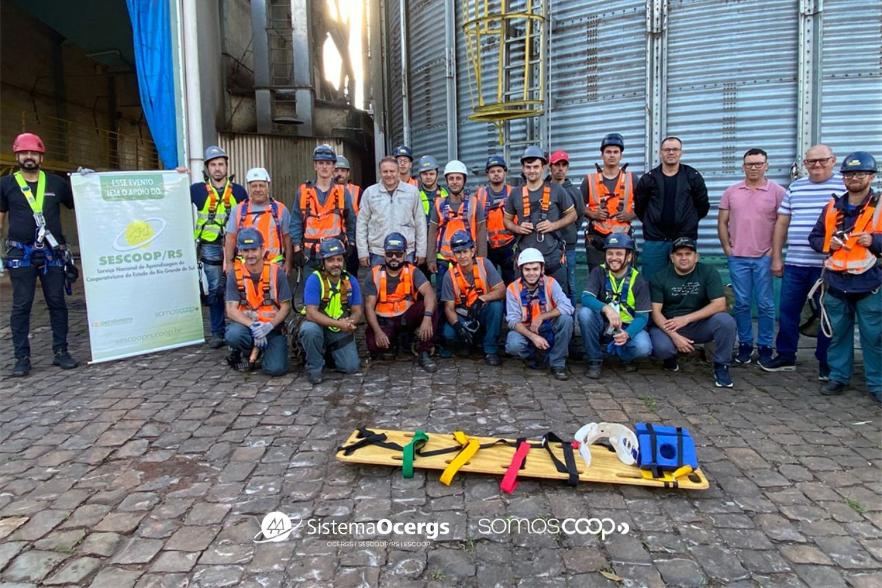 Colaboradores da Cotriel, equipados com EPIs, posam após treinamento sobre segurança no trabalho em frente a silos da cooperativa, com apoio do Sescoop/RS.