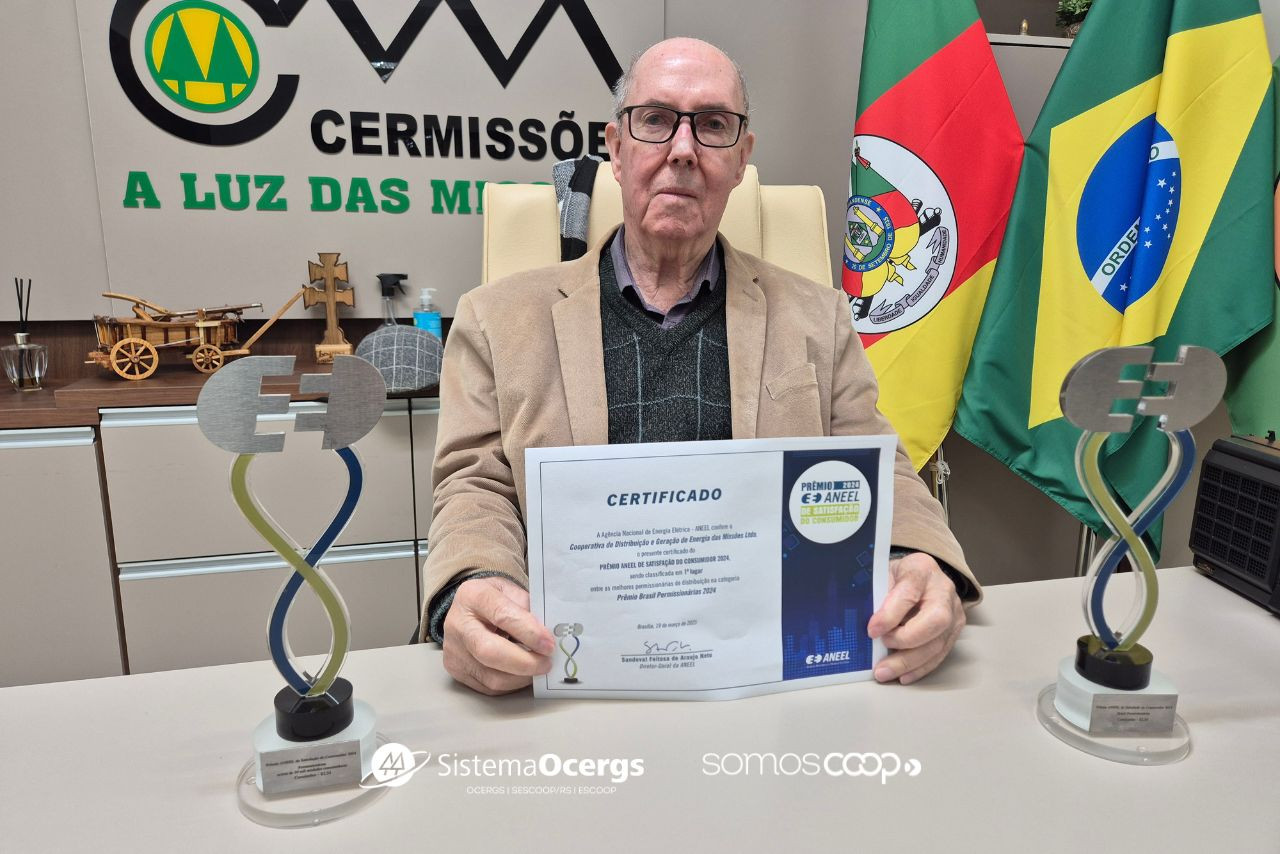 Presidente da Cermissões, Diamantino Marques dos Santos, exibe o certificado da ANEEL, ladeado por dois troféus do Prêmio de Satisfação do Consumidor, na sede da cooperativa.