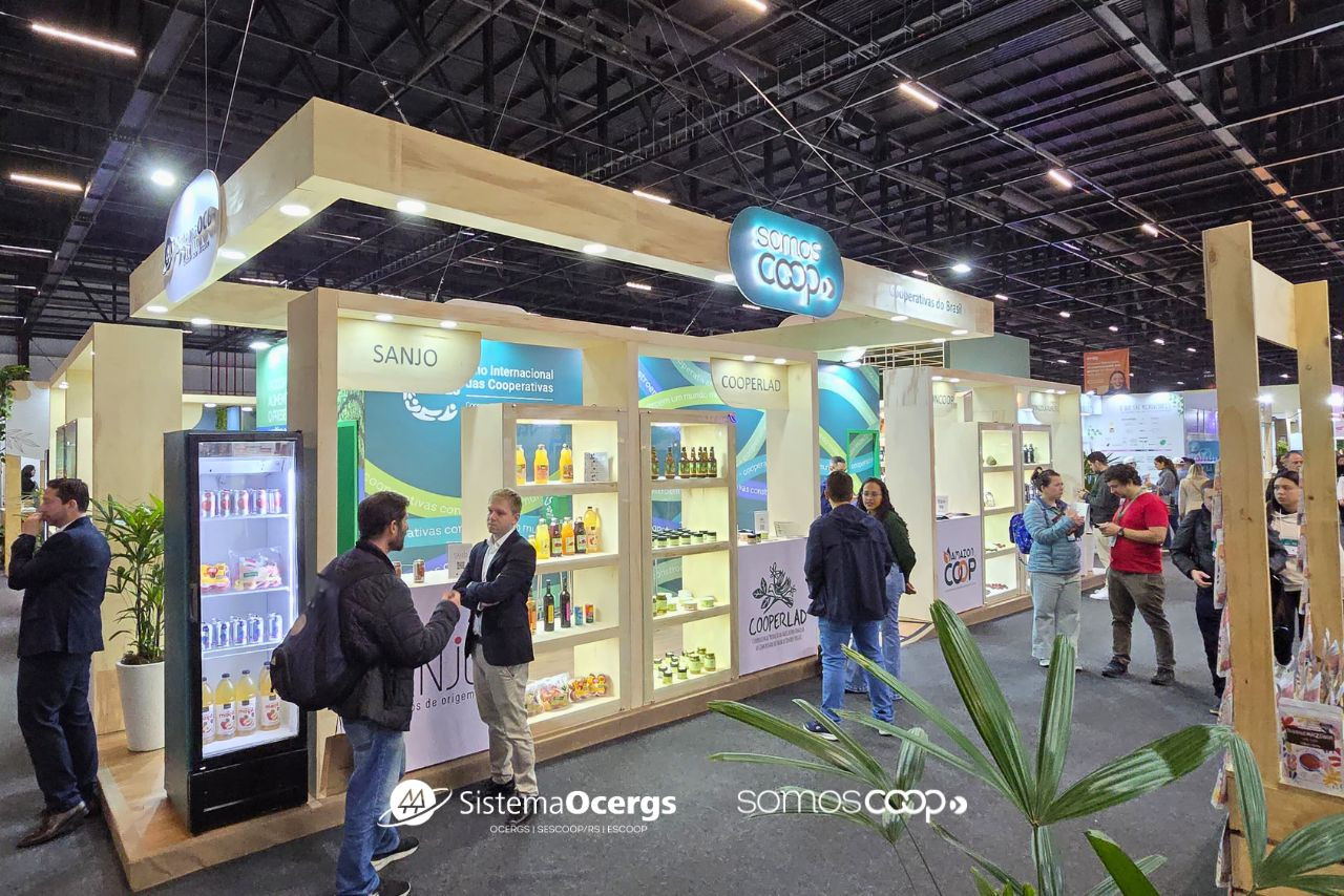 Estande institucional SomosCoop na Naturaltech 2025 exibe produtos de diversas cooperativas brasileiras, com grande movimentação de visitantes no espaço.