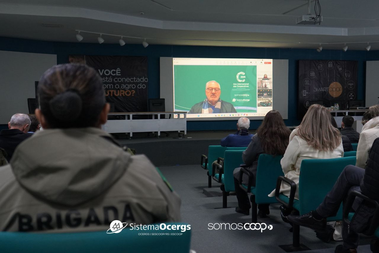Presidente do Sistema Ocergs, Darci Hartmann, participa de modo remoto do Fórum de Meio Ambiente do Cooperativismo Gaúcho. Público está na plateia do auditório da CCGL, em Cruz Alta.