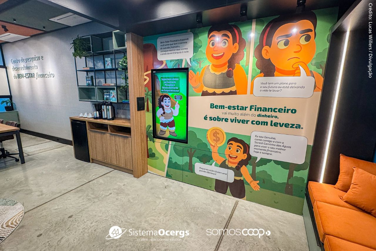 Imagem do Centro de Pesquisa e Desenvolvimento de Bem-Estar Financeiro da Sicredi Caminho das Águas, com painéis ilustrados, frases motivacionais e ambiente moderno voltado à educação financeira e à interação com o público. 