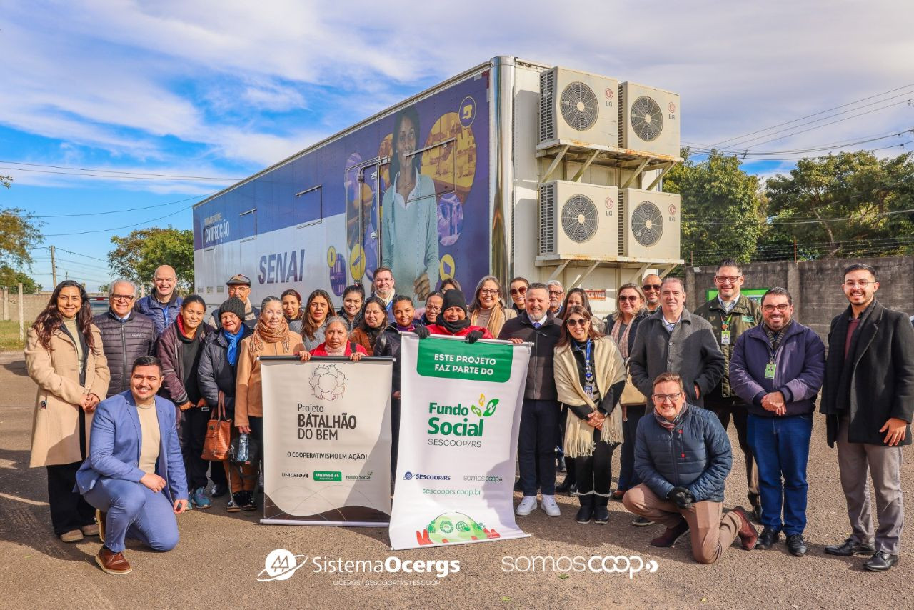 Participantes do projeto Batalhão do Bem posam para foto em frente ao caminhão do SENAI.